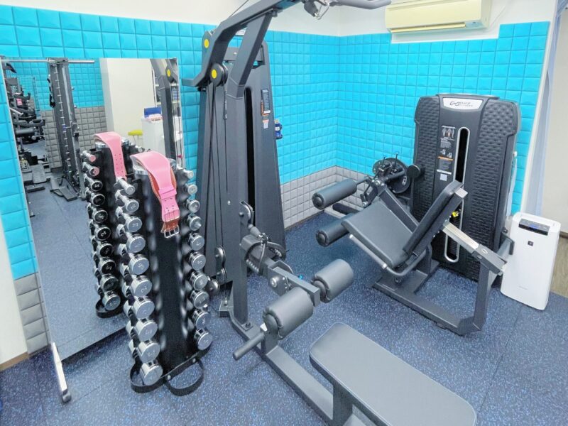 マシンやダンベルが映ったパーソナルジムの内装写真